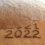 New year 2022 and old year 2021 on sandy beach with waves