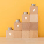 Wooden blocks with Japanese yen signs and coins.