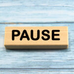 pause wording  or text on wood block with blue background.Copy space and business concept.