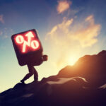 Man carrying heavy stone with growing interest rate symbol