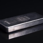 Old and scratched silver bar, side view, on black glass
