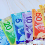 Multiple Canadian cash dollar, banknotes of varying denominations arranged