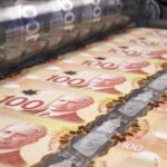 Printing money canadian dollar bills on a print machine in typography.. Finance, tax, stock market and investment, making money concept.
