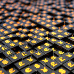 Golden shiny currency symbols US dollar, Euro, British pound, Japanese yen on black cubes.