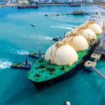 LNG (Liquefied natural gas) tanker anchored in Gas terminal gas tanks for storage. Oil Crude Gas Tanker Ship. LPG at Tanker Bay Petroleum Chemical or Methane freighter export import transportation